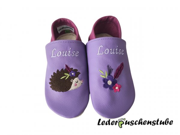 Lederpuschen lila-flieder, Namen beiderseits Spann weiß, Indianer Igel (Igel creme-braun-schwarz-altrosa) Blume (dunkellila-creme) Feder (flieder) sowie links Feder Blume ( Feder flieder; Blumen dunkellila, pink -creme)